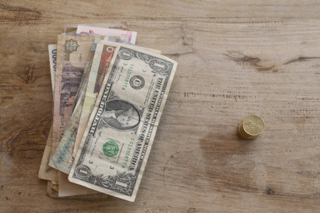 collection of various international paper money including us dollar and foreign currency bills arranged on weathered wooden surface with copy space for financial conceptsの写真素材