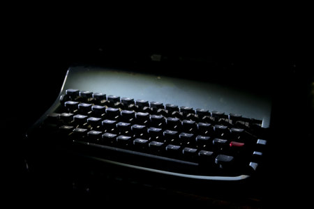old dusty typewriter with original keys illuminated in moody darkness, perfect for writing, nostalgia, creativity and retro communication conceptsの写真素材