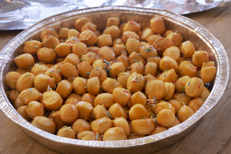 pignolata, traditional Italian honey-glazed fried dough balls with colorful sprinkles in aluminum tray. classic sicilian carnival dessert sweet pastryの写真素材