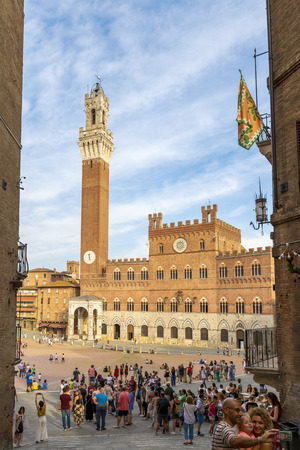 Siena, Italy - September 1, 2019: View of the Palazzo Pubblico and the Torre del Mangia overlooking Piazza del Campo full of touristsのeditorial素材