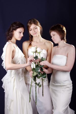 three girls models with white roses in handsの写真素材