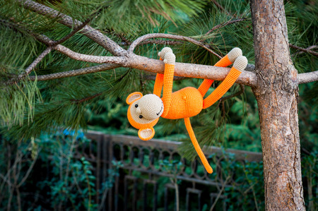Soft toy - orange monkey climb on the treeの写真素材