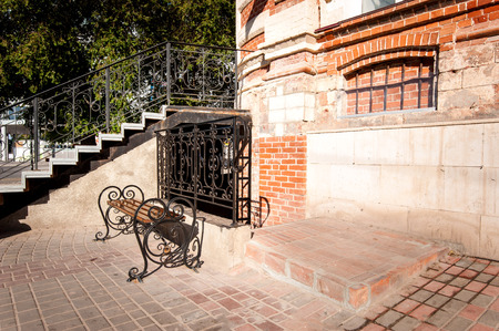 Forged bench near ladder to old buildingの写真素材