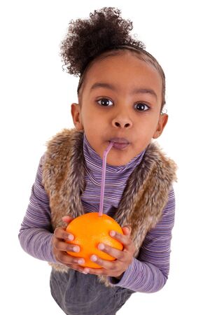 Little black girl drinking orange juice with a strawの写真素材