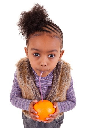 Little black girl drinking orange juice with a strawの写真素材