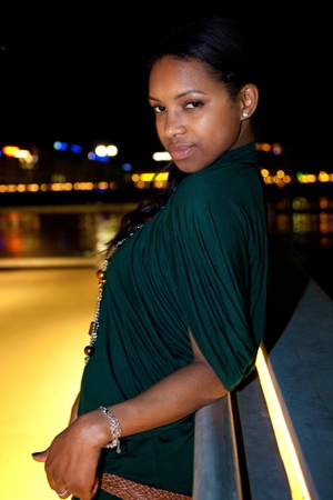 Portrait of young african american woman in city at night.の写真素材