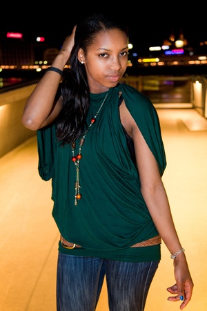 Portrait of young african american woman in city at night.の写真素材