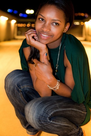 Portrait of young african american woman in city at night.の写真素材