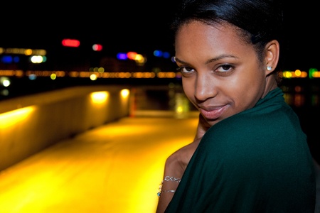 Portrait of young african american woman in city at night.の写真素材