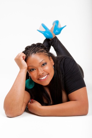Portrait of a young beautiful black woman lied on the floor and smilingの写真素材