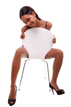 Sexy young african american woman posing in chair, isolated on white backgroundの写真素材