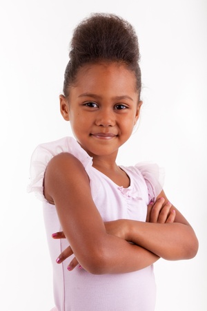 Cute little African Asian girl smiling ,with folded armsの写真素材