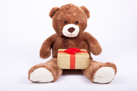 Seated teddy bear with gift boxes, over a white backgroundの写真素材