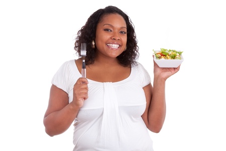 Young african american woman eating salad, isolated on white backgroundの写真素材