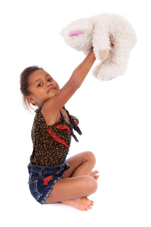 Cute little African Asian girl playing with a teddy bear,  over white backgroundの写真素材