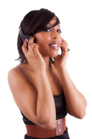 Young beautiful black woman in black dress listening to music, isolated on white backgroundの写真素材