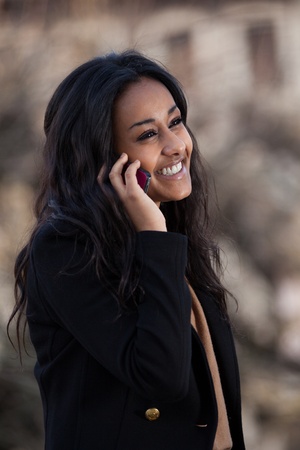 Outdoor of a portrait happy young black  teenage girl using a mobile phoneの写真素材
