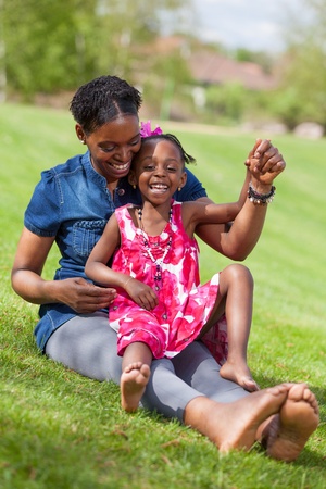 Portrait of a adorable african mother with her daughter in the gardenの写真素材