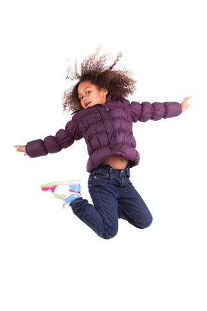 Portrait of cute Young African Asian  girl jumping, over gray backgroundの写真素材