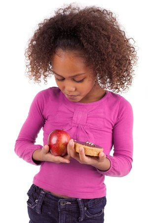 Little African Asian girl hesitating between fruits or  candy,isolated on white backgroundの写真素材
