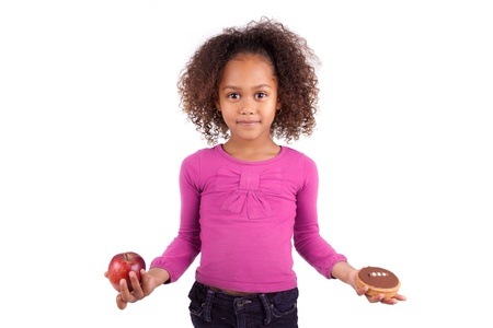 Little African Asian girl hesitating between fruits or  candy,isolated on white backgroundの写真素材