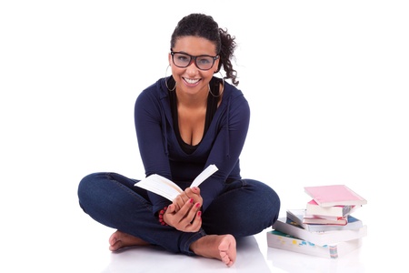Young African American student girl reading a book, isolated on white backgroundの写真素材