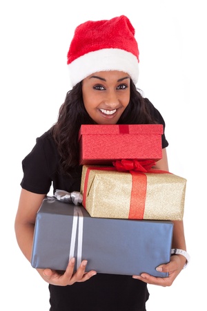 Young African American woman wearing a santa hat holding gift boxes, isolated on white backgroundの写真素材