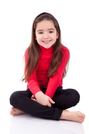Portrait of a cute young caucasian girl seated on the floorの写真素材