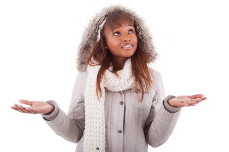 Young african american woman wearing winter clothes holding something in her hand, isolated on white backgroundの写真素材