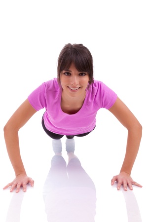 Young beautiful caucasian fitness woman doing push up exercises on floor,isolated on white backgroundの写真素材