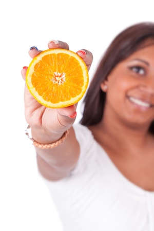 Young happy indian woman holding an orange slice, isolated on white backgroundの写真素材
