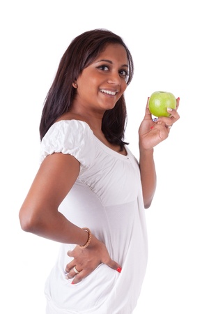 Young happy indian woman holding an apple, isolated on white backgroundの写真素材