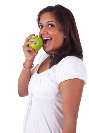 Young indian woman eating an apple, isolated on white backgroundの写真素材
