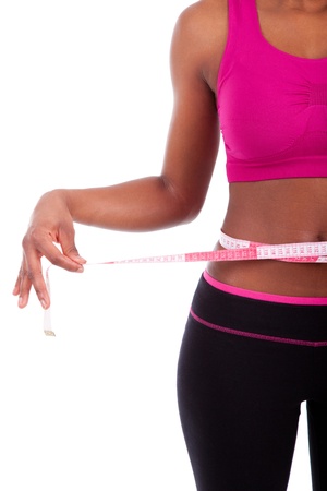 African American Fitness woman measuring her belly, isolated on white backgroundの写真素材