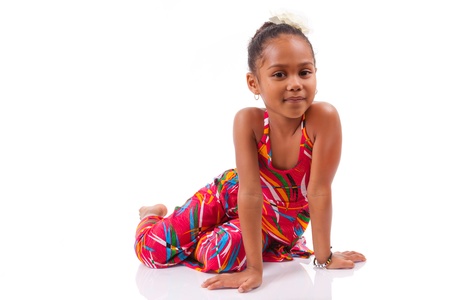 Portrait of a cute young African Asian girl seated on the floorの写真素材