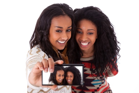 Young black african american teenage girls taking pictures with cell phone, isolated on white background - african peopleの写真素材