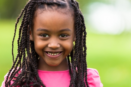 Outdoor close up portrait of a cute young black girl smiling - African peopleの写真素材
