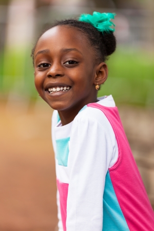 Outdoor close up portrait of a cute young black girl smiling - African peopleの写真素材