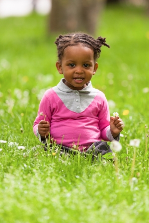 Outdoor close up portrait of a cute little young black girl smiling - African peopleの写真素材