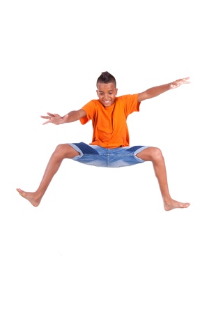 Portrait of a cute teenage black boy jumping over white background - African peopleの写真素材