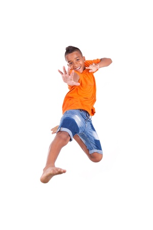 Portrait of a cute teenage black boy jumping over white background - African peopleの写真素材