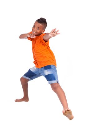 Portrait of a cute teenage black boy jumping over white background - African peopleの写真素材