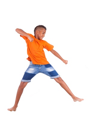 Portrait of a cute teenage black boy jumping over white background - African peopleの写真素材