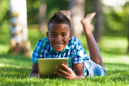 Outdoor portrait of student black boy using a tactile tablet - African peopleの写真素材
