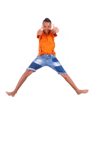 Portrait of a cute teenage black boy jumping over white background - African peopleの写真素材