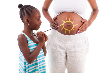 Little african american girl painting on her mother's belly, isolated on white background - African peopleの写真素材
