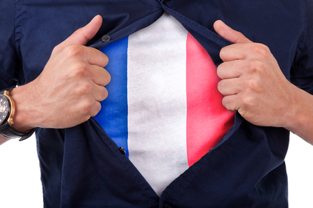 Young sport fan opening his shirt and showing the flag his country France, French flagの写真素材