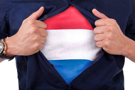 Young sport fan opening his shirt and showing the flag his country Netherlands, Dutch flagの写真素材