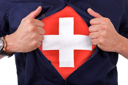 Young sport fan opening his shirt and showing the flag his country switzerland, swiss flagの写真素材