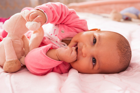 Adorable little african american baby girl playing with a plush - Black people